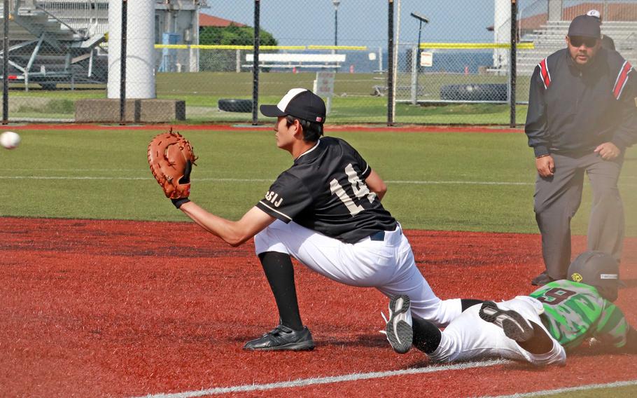 Kubasaki's Luka Koja dives into first base ahead of the throw to ASIJ's Leo Mentzas.