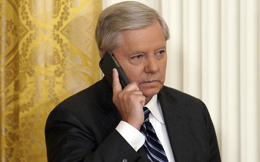 Sen. Lindsey Graham holds a cell phone to his ear at the White House in Washington, D.C., on March 3, 2022.