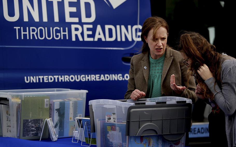 Lauren Steiner, program manager, helps military spouse Mikaela Mintz find a book to read to her children Friday, March 31, 2023, afternoon. The United Through Reading van regularly stops at the Armed Services YMCA in Virginia Beach.