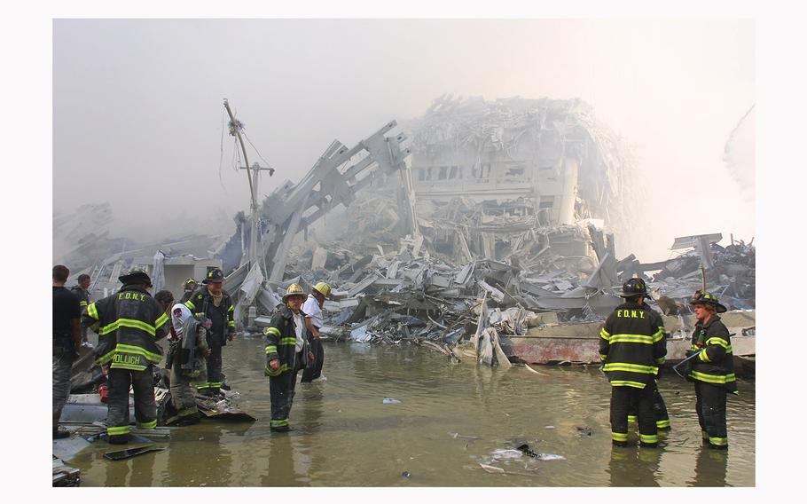 New York City firefighters work at the World Trade Center after two hijacked planes crashed into the Twin Towers on Sept. 11, 2001, in New York. 