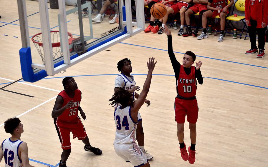 Kaiserslautern freshman Caleb Ringer floats a shot over Ramstein junior Tyrell Edwards during pool-play action of the DODEA European basketball championships on Feb.14, 2024, at the Wiesbaden Sports and Fitness Center on Clay Kaserne in Wiesbaden, Germany.