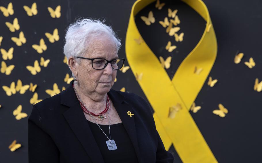 Holocaust survivor Hannah Gofrit stands next to an installation of a yellow ribbon with butterflies Sunday, May 5, 2024, in Tel Aviv on the eve of Holocaust Remembrance Day.