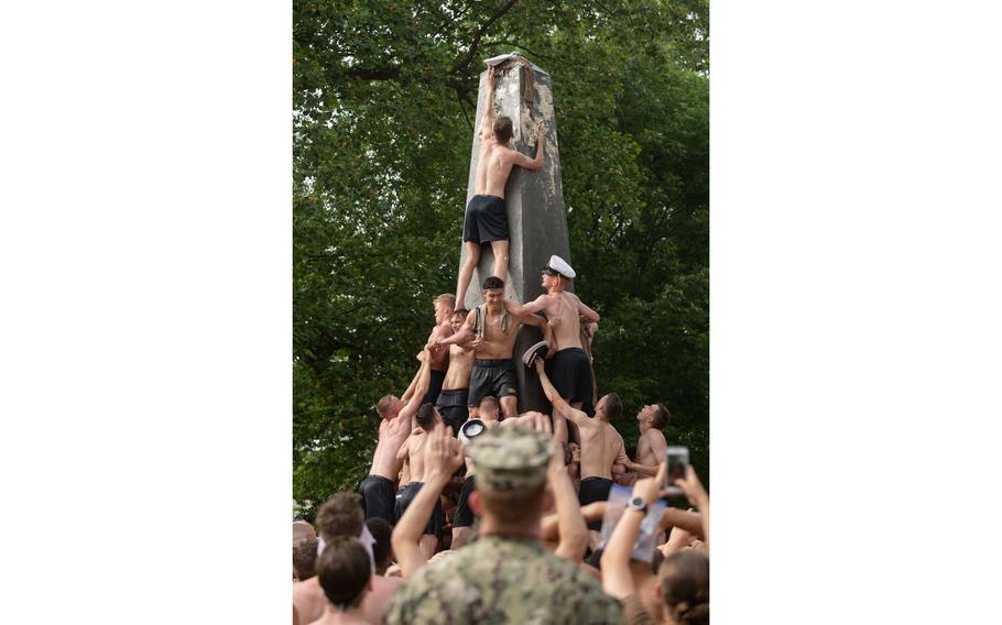 Midshipman 4th Class Michael Lancaster, 19, from Signal Mountain, Tenn., places the midshipman cover atop the Herdon Monument. The class of 2024 completed the climb in 3 hours and 41 minutes, the second-slowest recorded time. The class of 2023 will get their chance to complete the climb Sunday, Aug. 22, after the climb was canceled in 2020 due to the pandemic. 