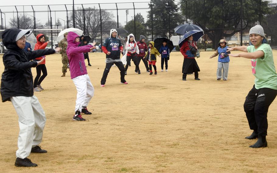 Runners warm up with Zumba during the 43rd annual Yokota Striders Frostbite Road Race at Yokota Air Base, Japan, Sunday, Jan. 21, 2024.