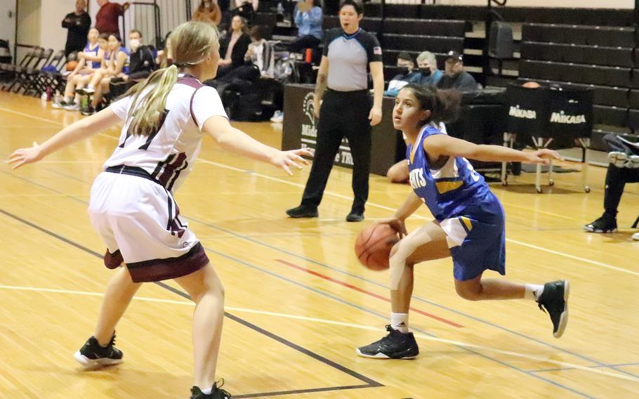 Christian Academy Japan's Devika Pramod dribbles against Zama's Lorelei Holt during Monday's Kanto Plain girls basketball game. The Trojans won 34-24.