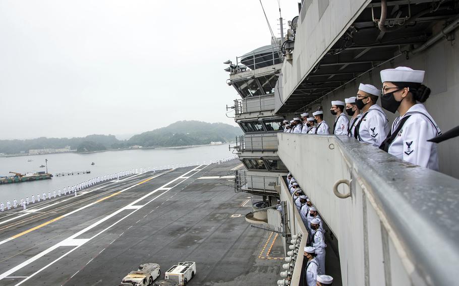 Sailors man the rails aboard the aircraft carrier USS Ronald Reagan as it departs Yokosuka Naval Base, Japan, Wednesday, May 19, 2021. 