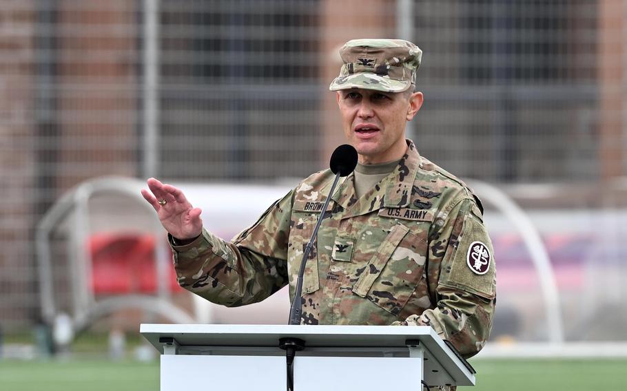 A man in an Army uniform gestures with one hand while speaking at a podium.