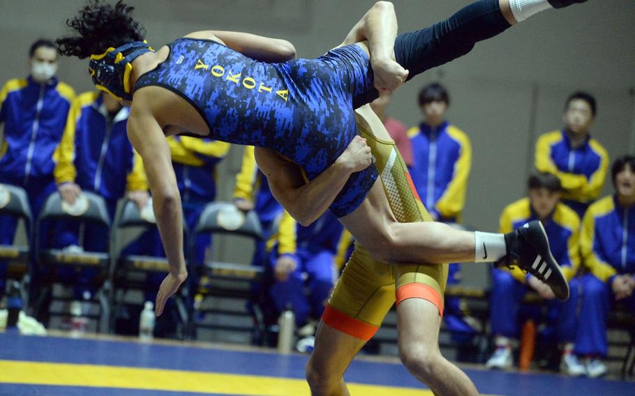 Yokota's Aaron Valiente is sent airborne by St. Mary's Nathaniel Twohig at 135 pounds  during Wednesday's Kanto Plain wrestling dual meet. Twohig won by technical fall 10-0 in 1 minute, 30 seconds and the Titans won the meet 46-5.