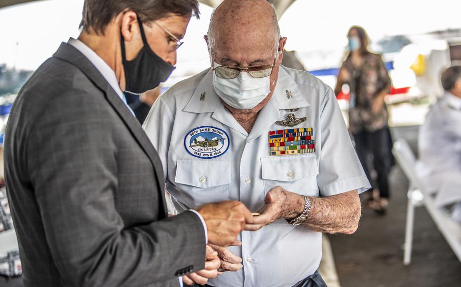 Defense Secretary Mark T. Esper presents World War II Veteran Jack DeTour with a coin at the luncheon during the 75th Anniversary of the End of World War II commemoration ceremony held aboard the Battleship Missouri Memorial, Sept. 2, 2020. 