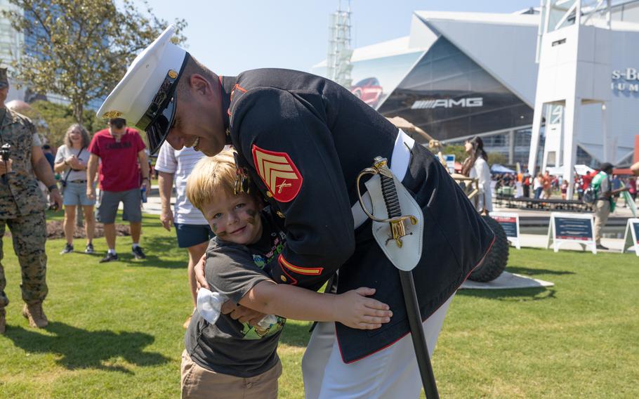 A Marine hugs a child.