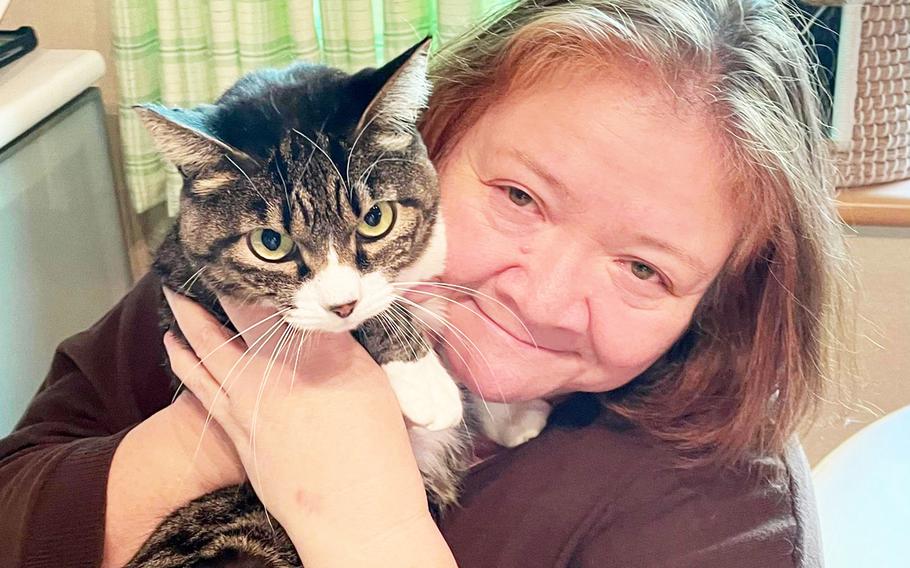 Natalie Kuri poses with Nyanjiro, a foster cat, at her home near Yokota Air Base, Japan, Feb. 28, 2023.