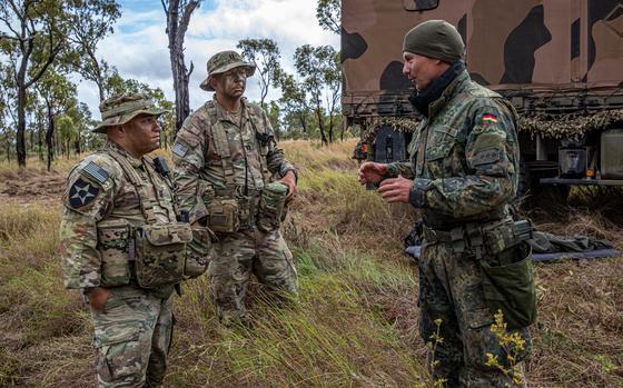 U.S. Army soldiers coaching the Talisman Saber 23 exercise talk with a German soldier at the tactical operations center (TOC), during the Joint Pacific Multinational Readiness Center (JPMRC) rotation at Townsville Field Training Area (TFTA), Townsville, Australia, July 26, 2023. Talisman Sabre is the largest bilateral military exercise between Australia and the United States advancing a free and open Indo-Pacific by strengthening relationships and interoperability among key Allies and enhancing our collective capabilities to respond to a wide array of potential security concerns.(U.S. Army photo by Spc. Mariah Aguilar)
