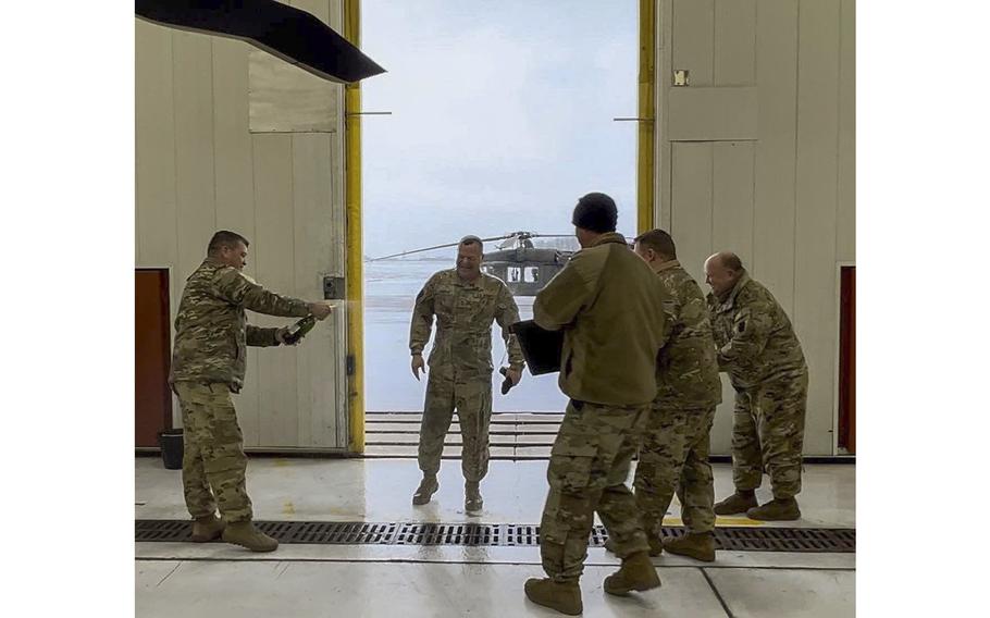 CW5 Charles Doyno, the 28th Expeditionary Combat Aviation Brigade’s former Command Chief Warrant Officer, gets sprayed down after flying his last flight earlier in December at the Johnstown Army Aviation Support Facility, Pa. Doyno retired on Friday, Dec. 30, 2022, after nearly 40 years of service.