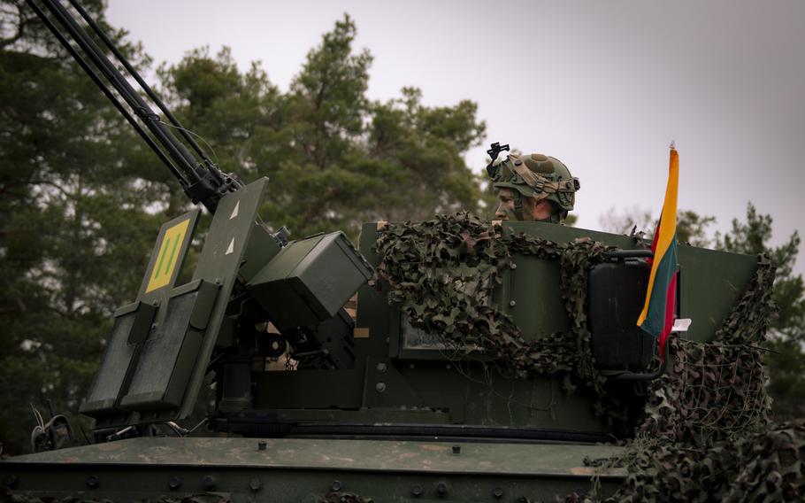 A Lithuanian soldier sits in the turret of an M577 armored personnel carrier.