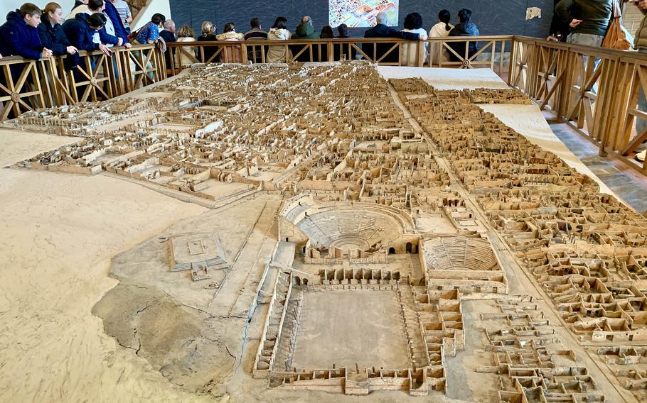 A large 3D diorama of Pompeii with people around it
