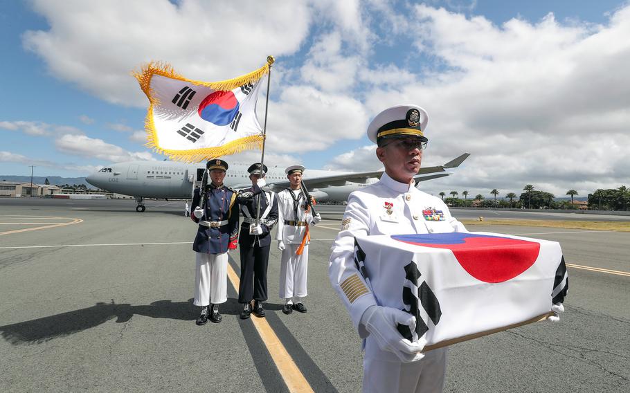 South Korean navy Senior Chief Petty Officer Choi Hojong carries the remains of his uncle, South Korean army Pfc. Choi Im-rak, at Joint Base Pearl Harbor-Hickam, Hawaii, July 25, 2023. 