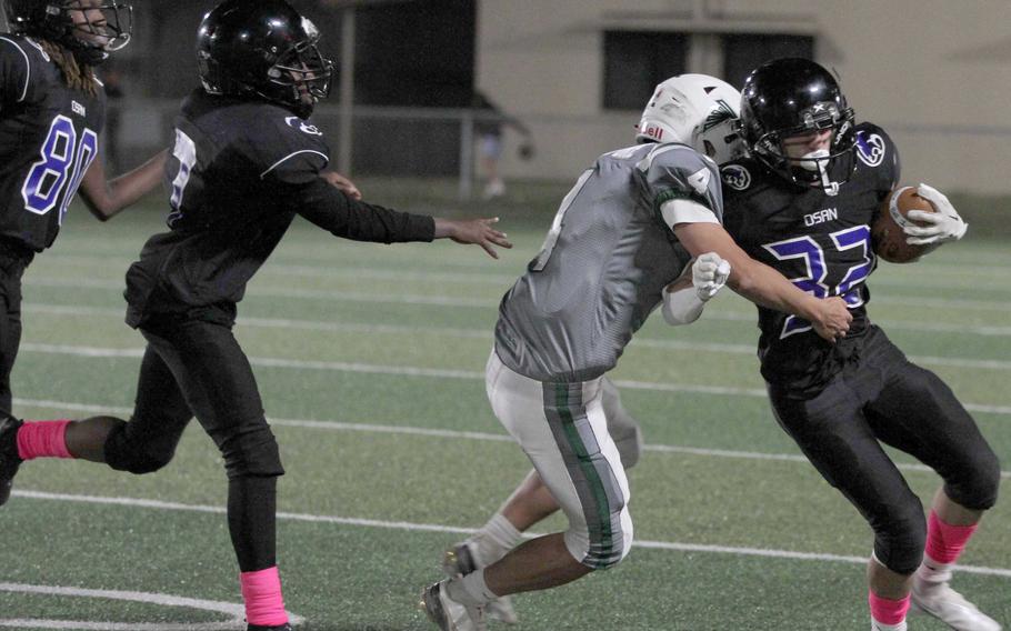 Singapore's Val Petersen tries to wrap up Osan ball carrier Kyle Foerst.