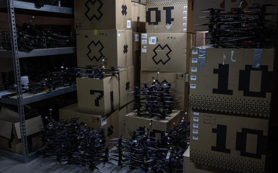 Piles of drones next to stacks of boxes.