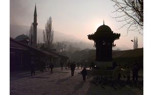 Sarajevo, Bosnia and Herzegovina, Dec. 10, 1997: The Sebilj fountain and the minaret of the 16th century Gazi Husrev-beg Mosque are sillouetted against the misty Dinaric Alps surrounding the capital. The wooden 18th century fountain stands on Baščaršija square. Legend has it that those who drink from the fountain will return to Sarajevo.

META TAGS: mosque; Islam; religion; mountains; Ottoman; architecture