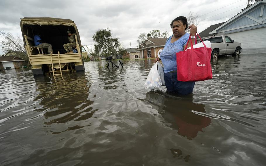 Jerilyn Collins returns to her destroyed home with the assistance of a Louisiana National Guard high-water vehicle to retrieve medicine for herself and her father, and a few possessions, after she evacuated from rising floodwater in the aftermath of Hurricane Ida in LaPlace, La., Monday, Aug. 30, 2021. 