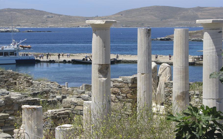 Ancient statues and columns from a millennia-old house stand just above the landing dock in the archaeological park at Delos, Greece, on May 25, 2019. The tiny island, a short boat ride from party-central Mykonos, was considered holy by ancient Greeks.  