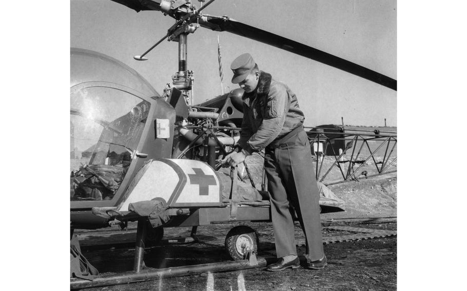First Lt. Paul Blomquist secures a patient to the outside of his Bell H-13 Sioux helicopter. Blomquist, who piloted the air ambulances of the 54th Medical Detachment, was one of five Army fliers ready to take off in the “bubble” chopper within five minutes of getting a call to evacuate a soldier. The helo was equipped with external stretchers — one on each side of the aircraft — to transport wounded soldiers quickly from battlefield to hospital. When only one patient was flown, sandbags were strapped to the other side to balance the weight.