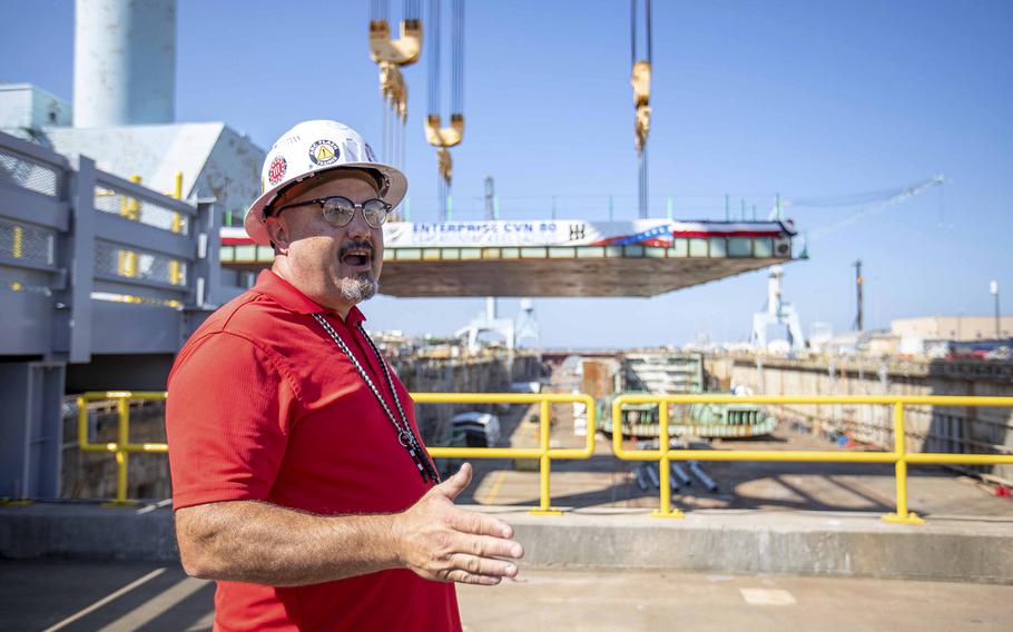 Facilities engineer Todd Meier speaks to the media regarding the USS Enterprise CVN 80 in the dry dock of the Newport News Shipbuilding yard on Aug. 26, 2022 ahead of Saturday’s keel-laying ceremony.