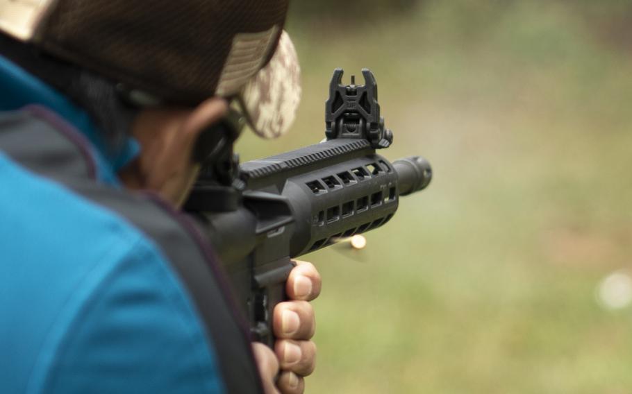 An AR-15 style pistol is fired at an outdoor range.