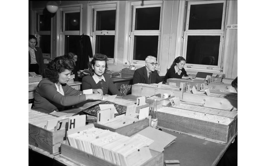 Investigators at the International Tracing Service — organized as a branch of the International Refugee Organization — search through thousands of cards in the organizations card index.