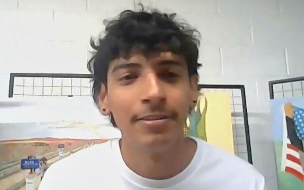 A screenshot from a video of a man in a white shirt.