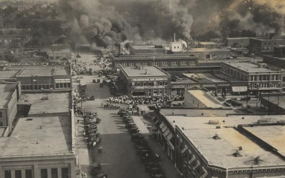 This photo provided by Department of Special Collections, McFarlin Library, The University of Tulsa shows crowds of people watching fires during the June 1, 1921, Tulsa Race Massacre in Tulsa, Okla. (Department of Special Collections, McFarlin Library, The University of Tulsa via AP)
