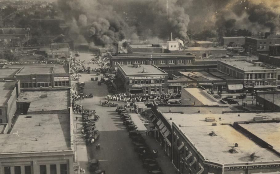 This photo provided by Department of Special Collections, McFarlin Library, The University of Tulsa shows crowds of people watching fires during the June 1, 1921, Tulsa Race Massacre in Tulsa, Okla. 