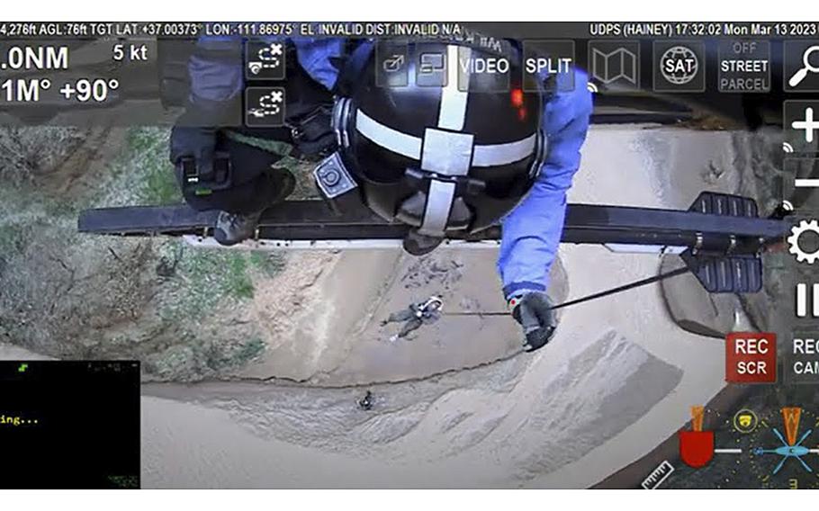 A screenshot from a video released by the Utah Department of Public Safety shows a helicopter crew hoisting hiker Ed Smith to safety from the Buckskin Gulch canyon in southern Utah on Monday. Smith is a physician associate and chief clinical officer for the Orthopaedic Medical Group of Tampa Bay. Two hikers with him who also work at the practice, Dr. Jeffrey Watson and William Romaniello, were killed when floodwaters tore through the canyon, authorities said.