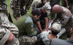 A U.S. Air Force special tactics operator assigned to the 24th Special Operations Wing conducts casualty care training with Ukrainian air force members near Vinnytsia, Ukraine, Aug. 6, 2021. The U.S. airman's face was obscured by military officials for security reasons.