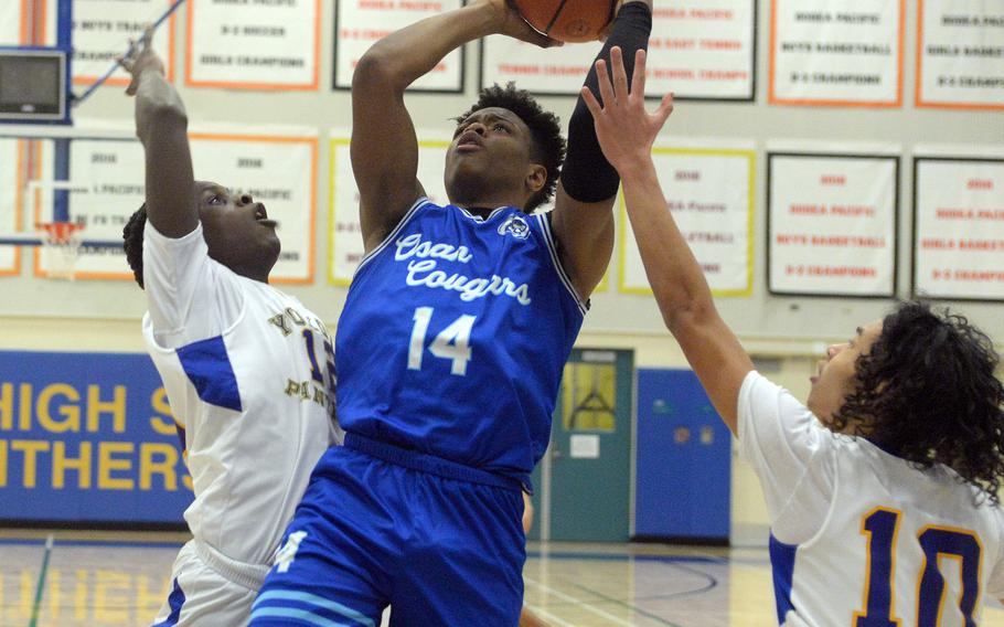 Osan's Jaylon Grant shoots between Yokota's Jai Bailey and Royce Canta during Wednesday's boys D-II final.