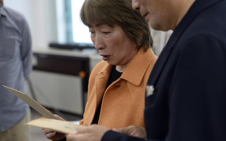 The children of Shichiro Matake look at sketches he made while incarcerated in Sugamo Prison after World War II. Nana Matake, left, and Kiyoshi Matake were given the drawings at Kurume University in Fukuoka, Japan, Nov. 24, 2023. 