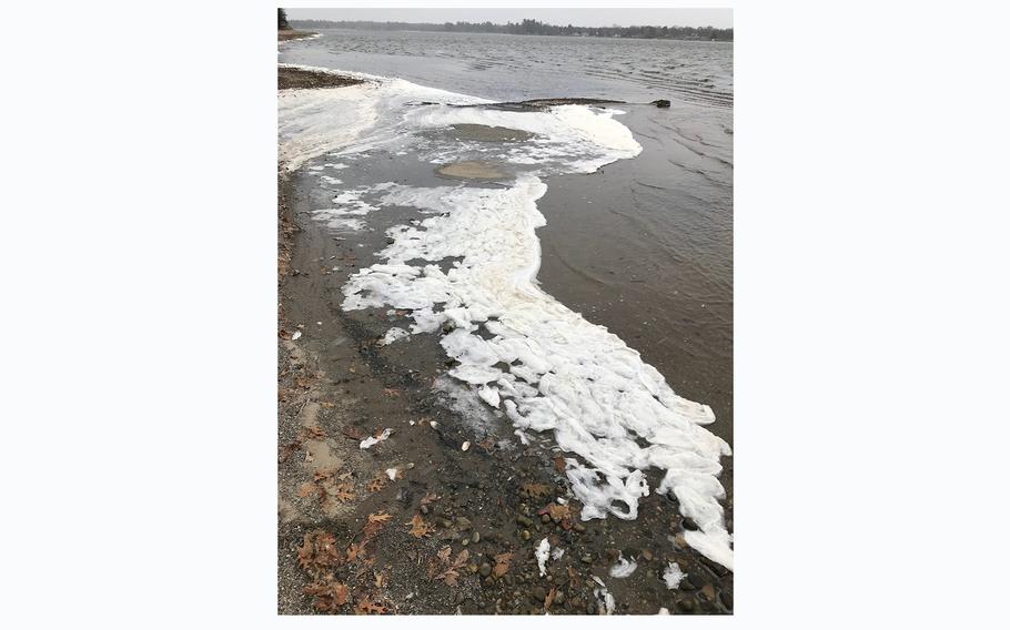 PFAS foam collects on the shore of Van Etten Lake in Oscoda, Michigan. The lake is next to the former Wurtsmith Air Force Base, from which PFAS was found seeping into the surrounding community. 