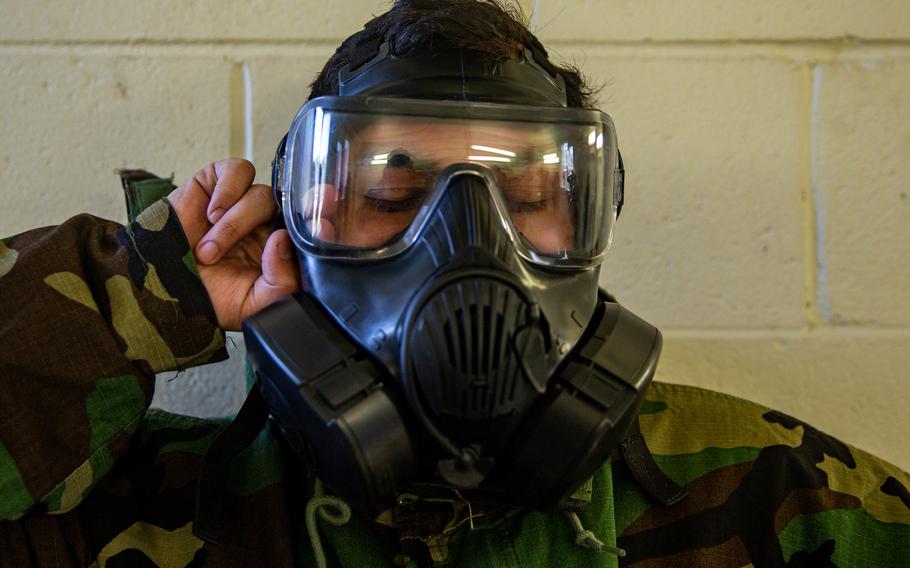 Marine Corps Lance Cpl. Melvin Molina breaks the seal of an M80 gas mask during training at Camp Lejeune, N.C., in April 2021. The secretary of the Navy has directed the Navy and Marine Corps study how facial hair affects the functionality of gas masks and to propose alternatives for service members with beards.