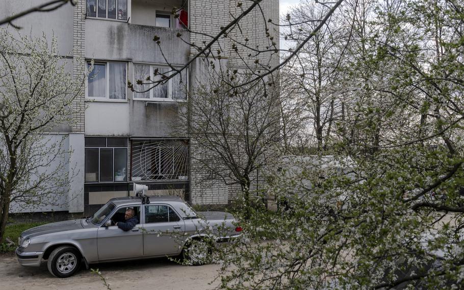 A man drives around a neighborhood where temporary housing units were built. 