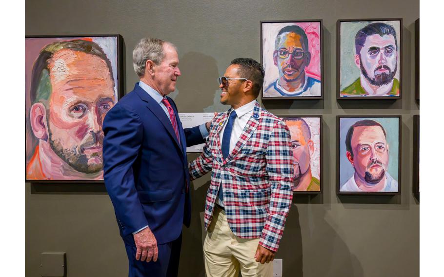 President George W. Bush speaks to veteran Daniel Casara next to the painting of Casara, top center, during a tour of Bush’s paintings for the exhibit, “Portraits of Courage: A Commander in Chief’s Tribute to America’s Warriors” at the Richard Nixon Library & Museum in Yorba Linda on Wednesday, March 13, 2024.
