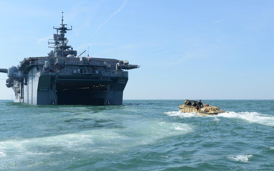 Sailors maneuver an amphibious resupply cargo vehicle into the well deck of the amphibious assault ship USS Bataan in 2016 in the Atlantic Ocean. 