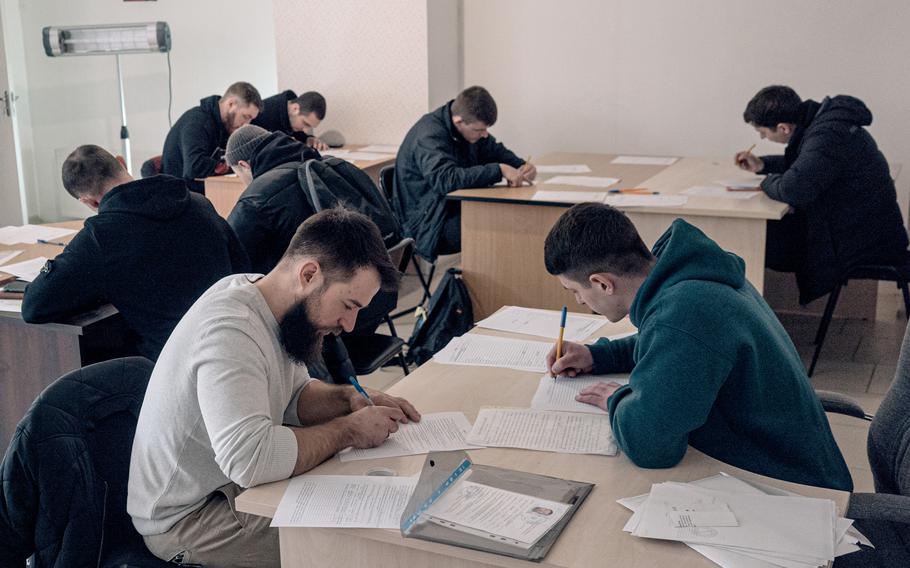 Volunteers fill out forms before being interviewed at an Azov Brigade recruitment center in Kyiv on March 21. 