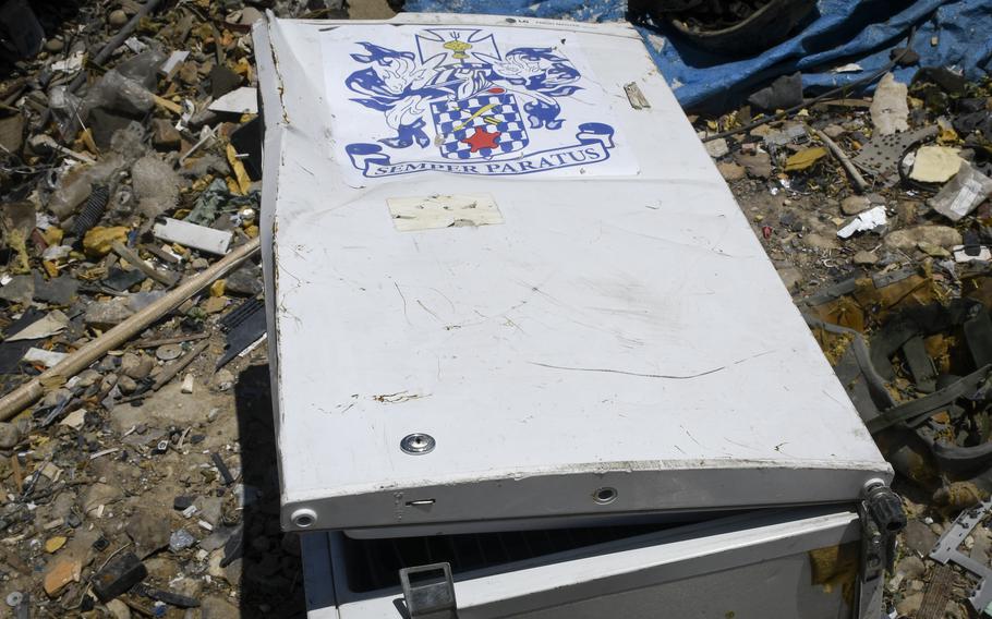 A small fridge containing the coat of arms of the U.S. Armys 16th Infantry Regiment, and the Latin motto, Semper Paratus, meaning Always Ready, lies slightly crushed at a trash yard outside Bagram Airfield, Afghanistan June 5, 2021. 