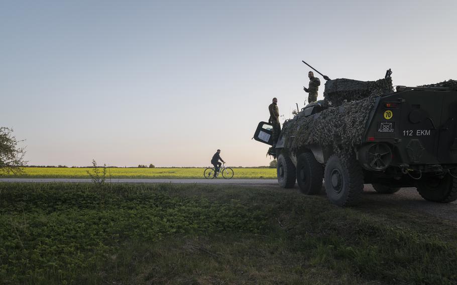 Estonian soldiers chat with a local. 