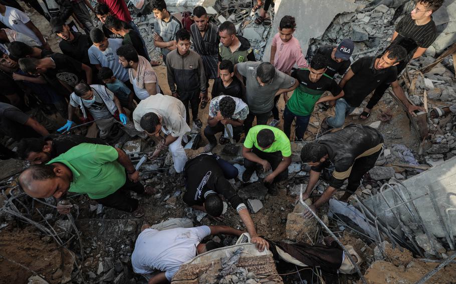 Palestinians search under rubble for victims of an airstrike on Tuesday.