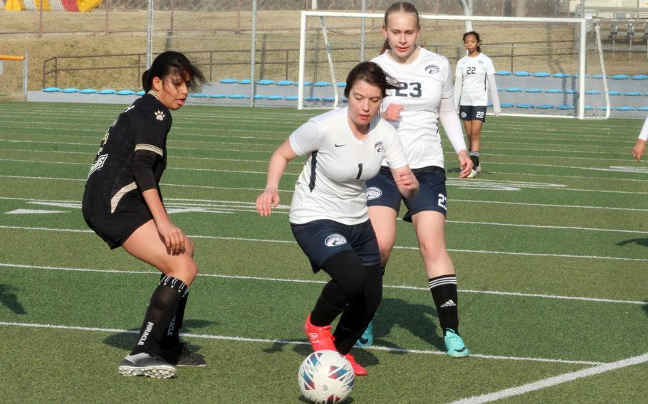 Osan’s Grace Williams plays the ball in front of teammate Kaysie Hendricks  and Dulwich College Seoul’s Adi Pal during Wednesday’s Korea girls soccer match. The teams played to a 1-1 draw.