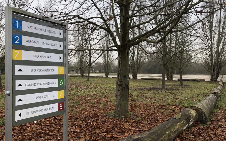 A sign near the entrance of the Alter Flugplatz in Frankfurt directs visitors to the park's buildings, including a former U.S. Army hangar, a museum and a green classroom. The Tower Cafe is now closed.