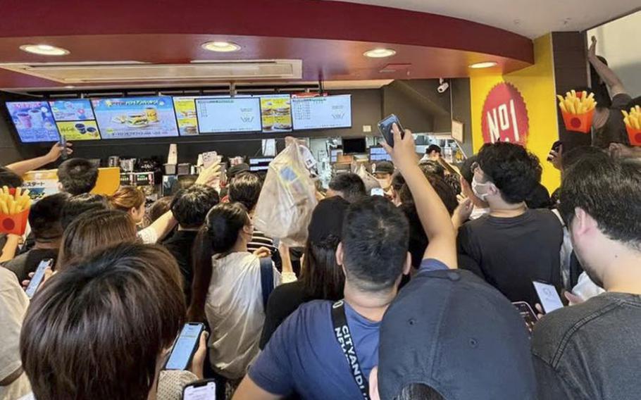 A crowded McDonald’s restaurant interior showing a dense crowd of customers gathered at the counter area. 