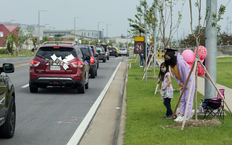 Humphreys High School senior Enemoria Vidana bows during a reverse parade for soon-to-be graduates at Camp Humphreys, South Korea, Thursday, May 27, 2021.