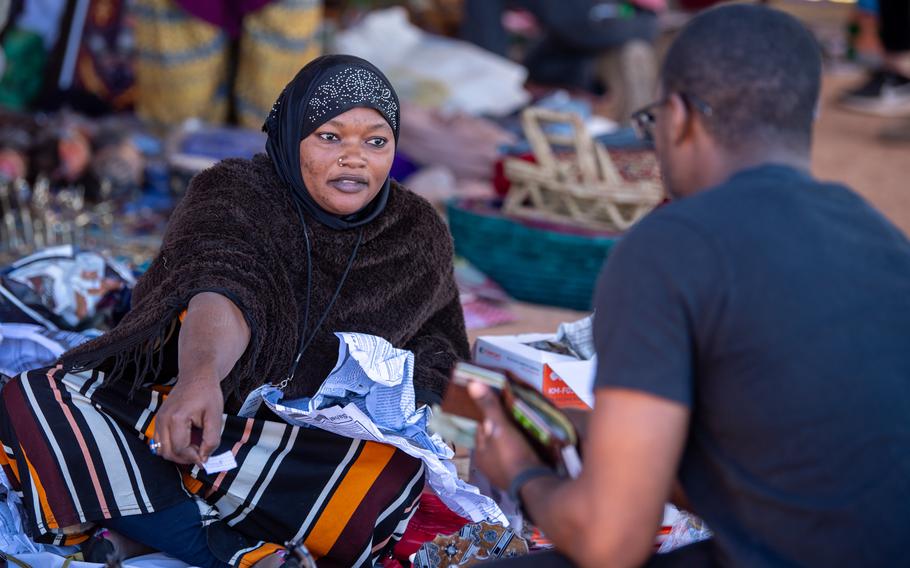 A vendor discusses an item for sale with a U.S. airman at the women’s bazaar at Base 201 in Agadez, Niger, on Dec. 2, 2023. American personnel made $11,350 worth of purchases at the event in support of area residents.